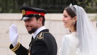 Jordan's Crown Prince Hussein and his wife Saudi Rajwa al-Seif leave in a convoy following their royal wedding ceremony in Amman on June 1, 2023. (Photo by Khalil Mazraawi / AFP)