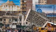 TOPSHOT - Police and civil defence gather as a collapsed billboard is removed from the October 6 overpass bridge in the Ghamra neighbourhood in central Cairo on June 1, 2023 during a sandstorm. (Photo by Khaled DESOUKI / AFP)