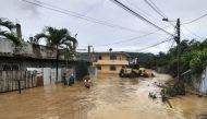 People wade through a flooded street in Esmeraldas, Ecuador, on June 4, 2023. Photo by Luis Cheme / AFP