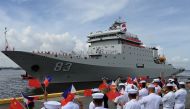 Philippine Navy personnel wave flags as they welcome the arrival of the Chinese naval training ship “Qi Jiguang” in Manila on June 14, 2023. (Photo by Jam Sta Rosa / AFP)