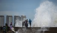 People enjoy high tides splashing on the sea front at a beach before the due onset of cyclone Biparjoy, in Karachi on June 13, 2023. (Photo by Asif Hassan / AFP)