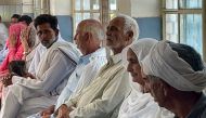 In this picture taken on June 20, 2023, relatives of migrants, who went missing after an overloaded trawler capsized and sank in the Ionian Sea, wait to provide DNA samples at a hospital in Bandli village, in Pakistan-administered Kashmir. (Photo by Sajjad QAYYUM / AFP)