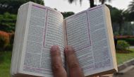 A demonstrator holds a copy of the Holy Quran with accompanying translation during a rally in Jakarta on July 2, 2023, as they protest against the burning of the Islamic holy book outside a Stockholm mosque that outraged Muslims around the world. (Photo by Adek Berry / AFP)