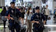 Armed policemen patrol Hong Kong International Airport on July 6, 2023. (Photo by ISAAC LAWRENCE / AFP)