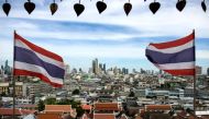 (FILES) This photo taken on June 26, 2023 shows Thai flags fluttering in the wind as the backdrop of Bangkok skyline seen from the Wat Saket Buddhist temple. (Photo by Amaury PAUL / AFP)
