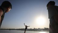 An Iraqi dives into the waters of the Tigris river in Baghdad on July 12, 2023, as temperatures soared past 45 degrees Celsius. (Photo by Ahmad AL-RUBAYE / AFP)
