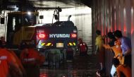 Rescue workers search for missing people along an underground tunnel, where some 15 cars were trapped in floodwaters after heavy rains, in Cheongju early on July 17, 2023. Photo by YONHAP / AFP