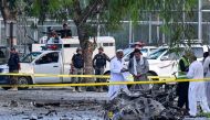 Security personnel gather at the site of the bomb blast in Hayatabad area of Peshawar on July 18, 2023. (Photo by Abdul MAJEED / AFP)
