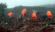 In this handout photograph released by India痴 National Disaster Response Force (NDRF) and taken on July 23, 2023, NDRF personnel search for victims at the site of a landslide at Irshalwadi village of Raigad district in Maharashtra state. Photo by AFP