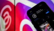 This photo illustration created in Washington, DC, on July 5, 2023, shows Threads, an Instagram app, on the App Store, in front of the logos of Instagram and Threads. (Photo by Stefani Reynolds / AFP)