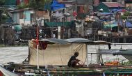 A man secures his boat at Baseco in Manila on July 26, 2023, as Super Typhoon Doksuri passes close to the northern tip of Luzon island. (Photo by Jam Sta Rosa / AFP)