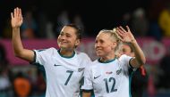 New Zealand's defender #07 Ali Riley (L) and New Zealand's midfielder #12 Betsy Hassett (R) greet supporters at the end of Australia and New Zealand 2023 Women's World Cup Group A football match between Switzerland and New Zealand at Dunedin Stadium in Dunedin on July 30, 2023. (Photo by Sanka Vidanagama / AFP)