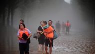 This photo taken on August 1, 2023 shows people evacuating from a flooded area after heavy rains in Zhuozhou, Baoding city, in China's northern Hebei province. Photos by CNS / AFP / China OUT