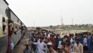 Railway workers repaire the tracks next to damaged carriages a day after the derailment of a passenger train in Nawab Shah on August 7, 2023. (Photo by Asif Hassan / AFP)