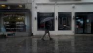 A pedestrian carries an umbrella while walking through rain in Washington, DC, on August 7, 2023. Photo by Stefani Reynolds / AFP