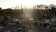 A resident looks around a charred apartment complex in the aftermath of a wildfire in Lahaina, western Maui, Hawaii on August 12, 2023. (Photo by Yuki Iwamura / AFP)