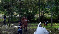 Members of the fire and rescue department inspect the crash site of a plane in Shah Alam, Malaysia's Selangor state on August 17, 2023. Photo by Muhammad Lutfi / AFP
