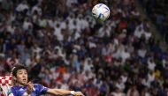 Japan's midfielder Wataru Endo jumps to head the ball during the Qatar 2022 World Cup round of 16 football match between Japan and Croatia at the Al Janoub Stadium in Al Wakrah, south of Doha on December 5, 2022.  (Photo by Adrian Dennis / AFP)