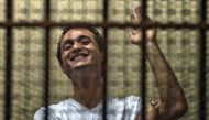 (FILES) Egyptian political activist Ahmed Douma reacts as he stands behind dock bars during his trial in Cairo on June 3, 2013, on charges of insulting president Mohamed Morsi. (Photo by Khaled DESOUKI / AFP)

