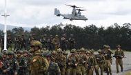 Philippine and Australian soldiers march in formation while a US marines V-22 Osprey hovers above during military exercise Alon (wave), a joint amphibious landing drill held at a naval base in San Antonio town in Zambales province, north of Manila on August 25, 2023. Photo by TED ALJIBE / AFP