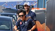 AlphaTauri's Australian driver Daniel Ricciardo (R) arrives on an electric scooter prior to the first practice session at The Circuit Zandvoort, ahead of the Dutch Formula 1 Grand Prix, in Zandvoort on August 25, 2023. (Photo by JOHN THYS / AFP)