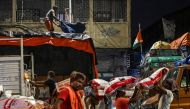 Workers load a truck with sacks of grains and other items to be sent to retail outlets across the city, at a wholesale market in Kolkata on August 31, 2023. Photo by DIBYANGSHU SARKAR / AFP