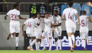 Ahmed Al Rawi (centre) celebrates with teammates after scoring Qatar's first goal.