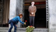 A woman lays a red rose at the feet of an image of Colombian artist Fernando Botero, at the entrance of the Antioquia Museum in Medellin, Colombia, on September 15, 2023. (Photo by Fredy Builes/ AFP)