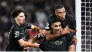 PSG’s Achraf Hakimi (centre) celebrates with teammates Kylian Mbappe (right) and Vitinha after scoring a goal against Borussia Dortmund in Paris, yesterday. AFP