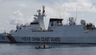 This photo taken on September 22, 2023 shows a wooden boat, with Philippine fisherman Arnel Satam on board, drawfed by a Chinese coast guard vessel after he was intercepted for attempting to enter Scarborough Shoal in disputed waters of the South China Sea. (Photo by Ted Aljibe / AFP)