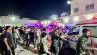 Soldiers and emergency responders gather around ambulances carrying wounded people after a fire broke out during a wedding at an event hall, outside the Hamdaniyah general hospital in Al-Hamdaniyah, Iraq on September 27, 2023. (Photo by Zaid Al-Obeidi / AFP)