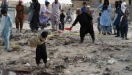 People gather at the site of a suicide bomb attack that targeted a religious gathering in Mastung district in Pakistan's Balochistan province on September 29, 2023.  (Photo by Banaras Khan / AFP)

