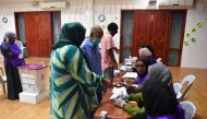 Election officials checks id cards of voters at a polling station during the second round of Maldives' presidential election in Male on September 30, 2023. (Photo by Mohamed Afrah / AFP)