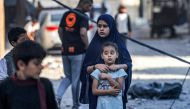 Youths look on during the search for the bodies of survivors and victims of a building collapse after Israeli bombardment in Rafah in the southern of Gaza Strip on October 19, 2023. (Photo by Mohammed Abed / AFP)
