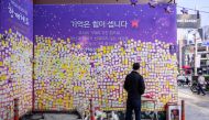 A man looks at flowers and notes left in memory of victims at the site of the October 29, 2022 crowd crush that killed more than 150 people during Halloween celebrations, in the popular Itaewon nightlife area in Seoul on October 25, 2023. Photo by ANTHONY WALLACE / AFP