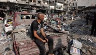 A man sits amid the destruction following Israeli strikes on Al-Shatee camp in Gaza City on October 28, 2023. (Photo by MOHAMMED ABED / AFP)