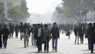People walk along a business street in Beijing on October 31, 2023. (Photo by WANG Zhao / AFP)