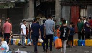 People queue for fresh water in the aftermath of Israeli strikes in Gaza City on October 28, 2023. Photo by MOHAMMED ABED / AFP