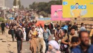 Palestinian families fleeing Gaza City and other parts of northern Gaza towards the southern areas, walk along a highway on November 9, 2023. (Photo by Mahmud Hams / AFP)