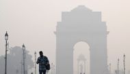 People walk along the Kartavya Path in front of the India Gate amid heavy smoggy conditions in New Delhi on November 13, 2023. Photo by Sajjad HUSSAIN / AFP