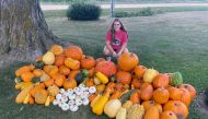 Lauren Schroeder with pumpkins, squash and gourds picked from her garden in Dixon, Iowa. Credit: Katie Schroeder