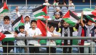 Supporters waving Palestinian flags pose for a picture prior to the 2026 FIFA World Cup AFC qualifier between Palestine and Australia. AFP
