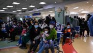 Children and their parents wait at an outpatient area at a children hospital in Beijing on November 23, 2023. (Photo by Jade Gao / AFP)
