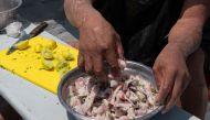 Peruvian artisan fisherman Cesar Melgarejo prepares a traditional ceviche for himself and colleagues with grey mullets (lisa in Spanish) caught in the early morning, while floating in the Lima Bay on December 1, 2023. (Photo by Cris Bouroncle / AFP)