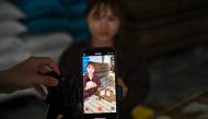 This photo taken on November 7, 2023 shows a mobile phone being used to shoot a TikTok video of TikToker Vi Thi Anh sorting out noodles at her workshop in Bac Giang province. Photo by Nhac NGUYEN / AFP