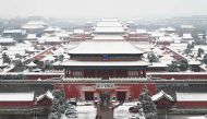 Snow-covered rooftops are seen in the Forbidden City after an overnight snowfall in Beijing on December 11, 2023. (Photo by GREG BAKER / AFP)
