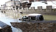 A vehicle believed to be washed away by the tsunami sits in water next to damaged buildings in the disaster-hit city of Noto, Ishikawa prefecture on January 9, 2024, after a major 7.5 magnitude earthquake struck the Noto region in Ishikawa prefecture on New Year's Day. Photo by JIJI PRESS / AFP