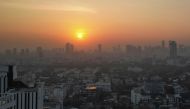 This aerial photo shows sunrise amid high levels of air pollution in Bangkok on January 9, 2024. (Photo by Lillian SUWANRUMPHA / AFP)