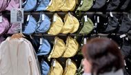 A woman walks past a display of bags at a Uniqlo retail store in Tokyo on January 16, 2024. Photo by Richard A. BROOKS / AFP