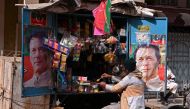 A vendor sits at his tuck shop displaying posters of Pakistan's former Prime Minister and Pakistan Tehreek-e-Insaf (PTI) leader Imran Khan, in Hyderabad on January 29, 2024. (Photo by Akram SHAHID / AFP)
 